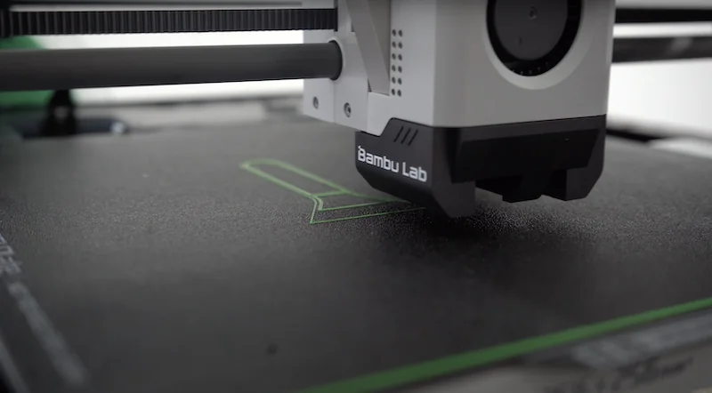 Bambu Lab P1P performing automatic bed leveling, tracing the first layer on the textured PEI plate