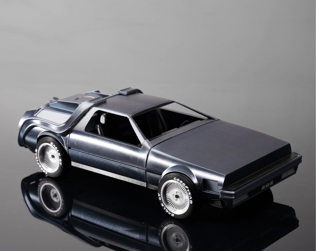 A silver metallic-silk DeLorean model printed in Bambu Lab PLA Silk+, with a glossy reflective finish