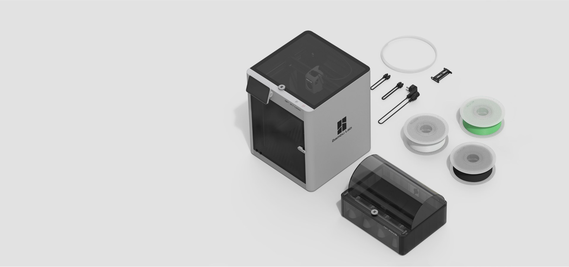 Bambu Lab X1E enterprise 3D printer shown with the AMS unit, spare filament spools and accessories