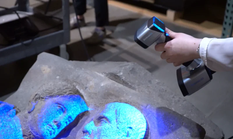 EinScan HX2 capturing a carved stone object with blue laser light, illustrating art and cultural-heritage digitization