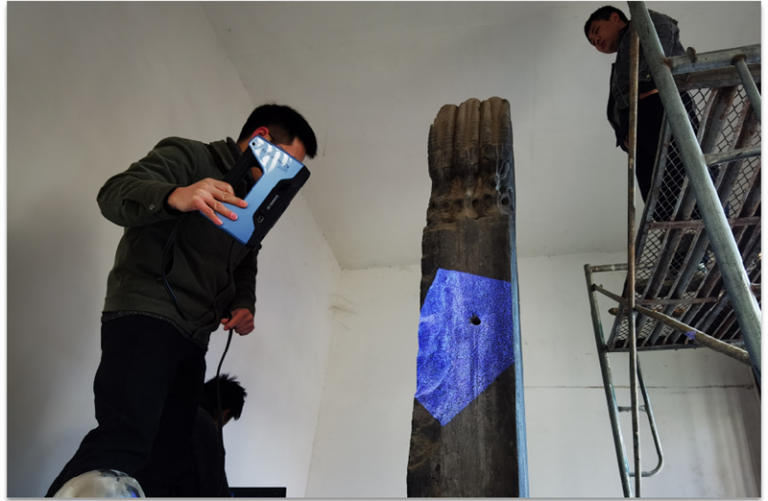 Operator using the EinScan Pro 2X V2 in Handheld Rapid mode to scan a large carved wooden statue