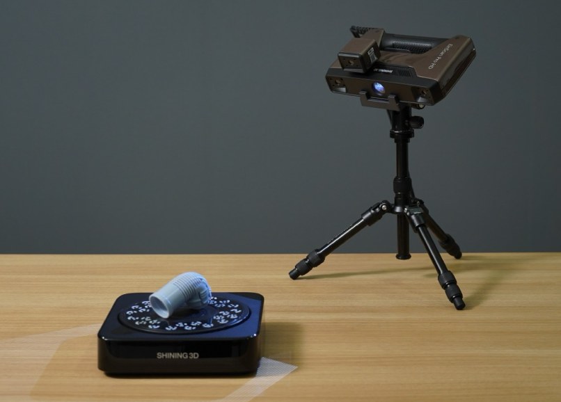 EinScan Pro HD scan head on a tripod beside the Industrial Pack automated turntable in a studio &mdash; Fixed mode