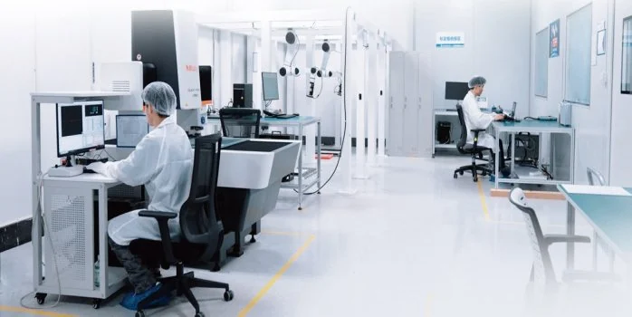 Technicians in lab coats at calibration benches with measuring instruments