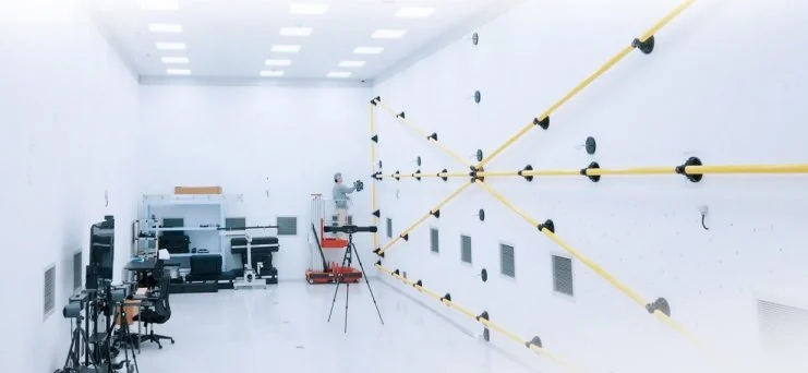 Large-volume accuracy hall with reference scale bars strung across the room