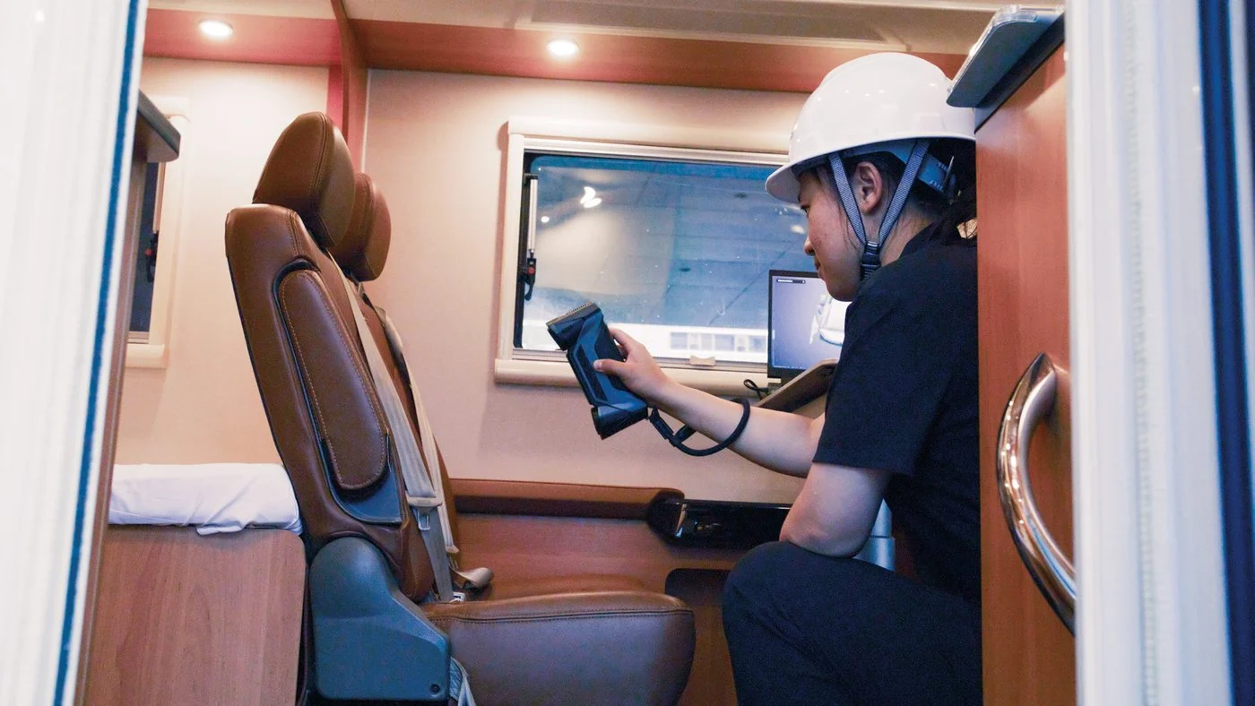 Technician in a hard hat scanning the inside of a camper van with a FreeScan Combo+ Wireless