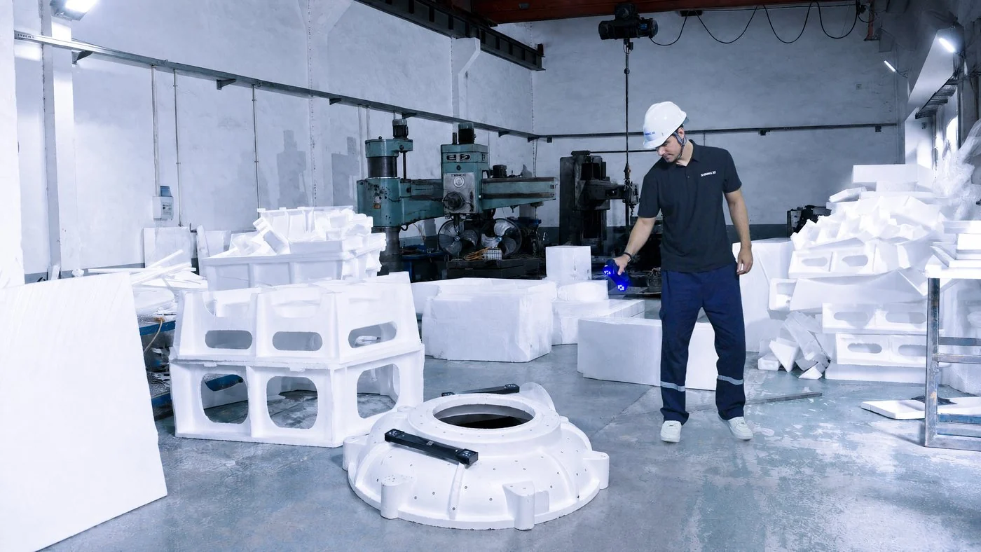 Technician in a hard hat scanning a large white casting pattern with a cable-free FreeScan Combo+ Wireless