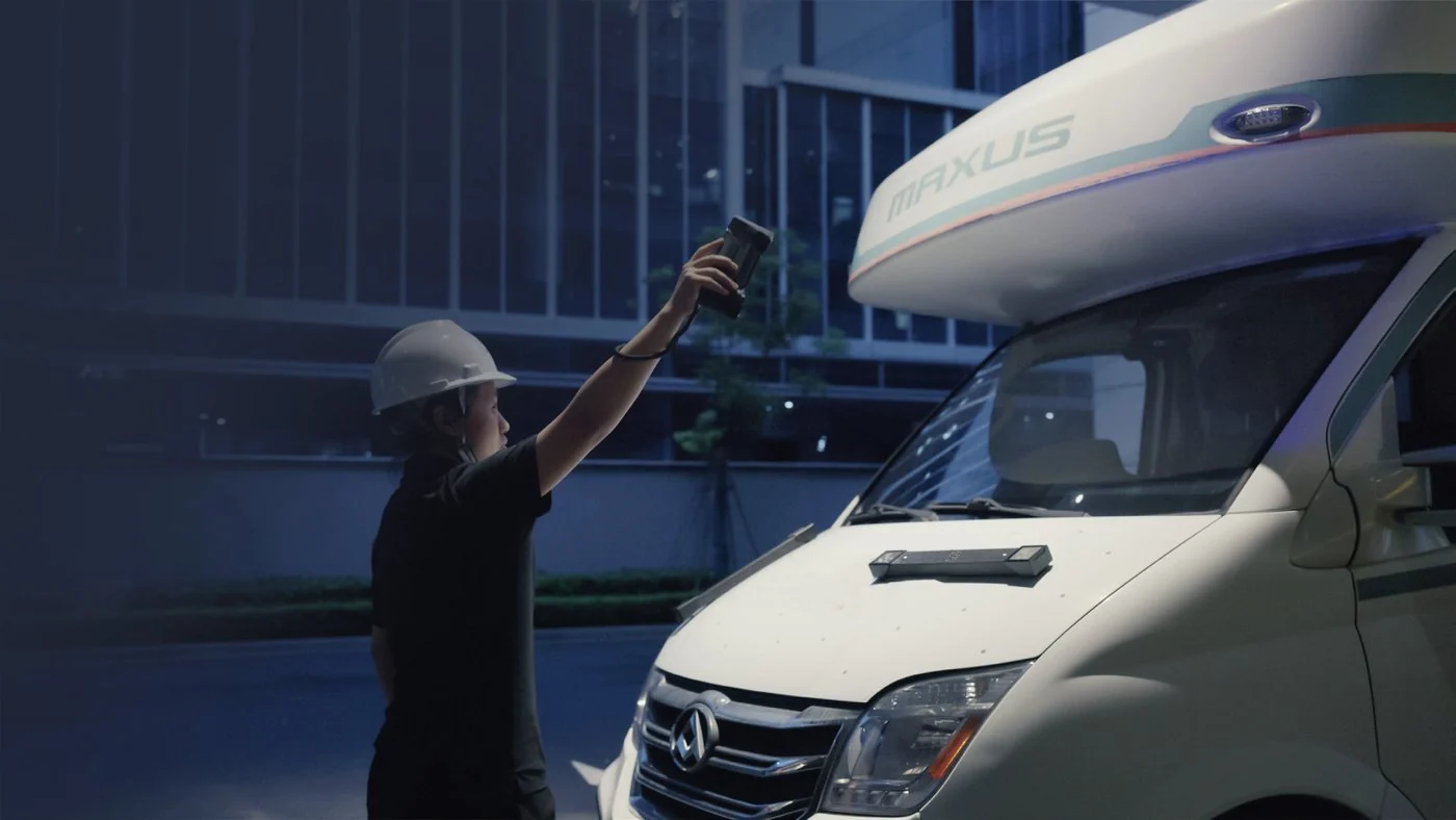 Technician in a hard hat holding a FreeScan Combo+ Wireless up to the front of a camper van with scale bars on the hood