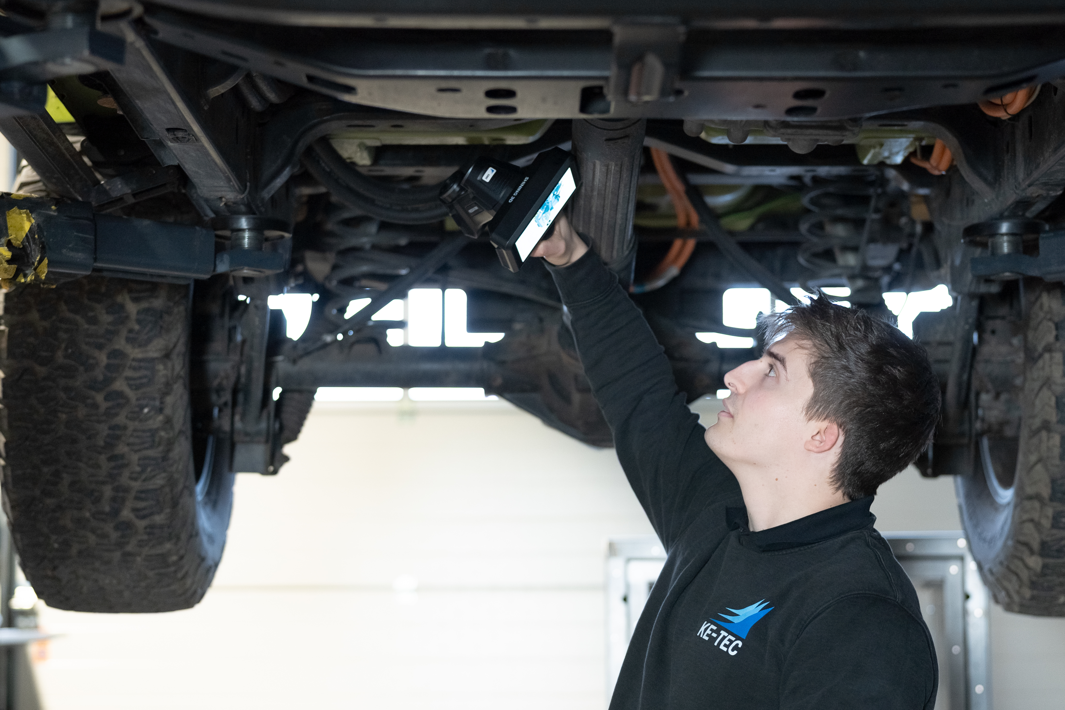 KE-TEC technician scanning heavy truck undercarriage with FreeScan Omni &mdash; standalone wireless scan-to-inspect on shop floor