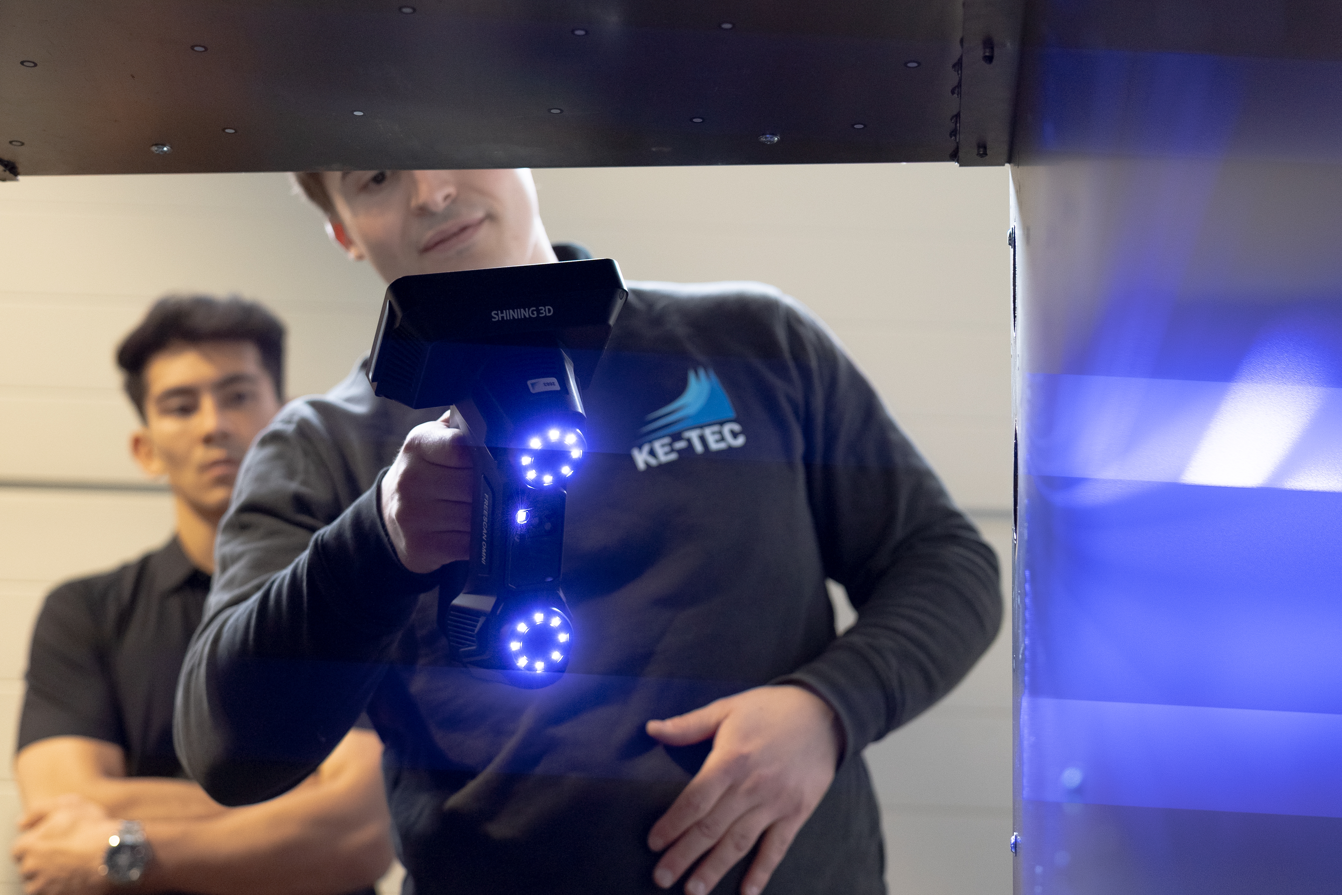 FreeScan Omni scanning complex industrial component &mdash; KE-TEC operator with active blue laser on metal tooling