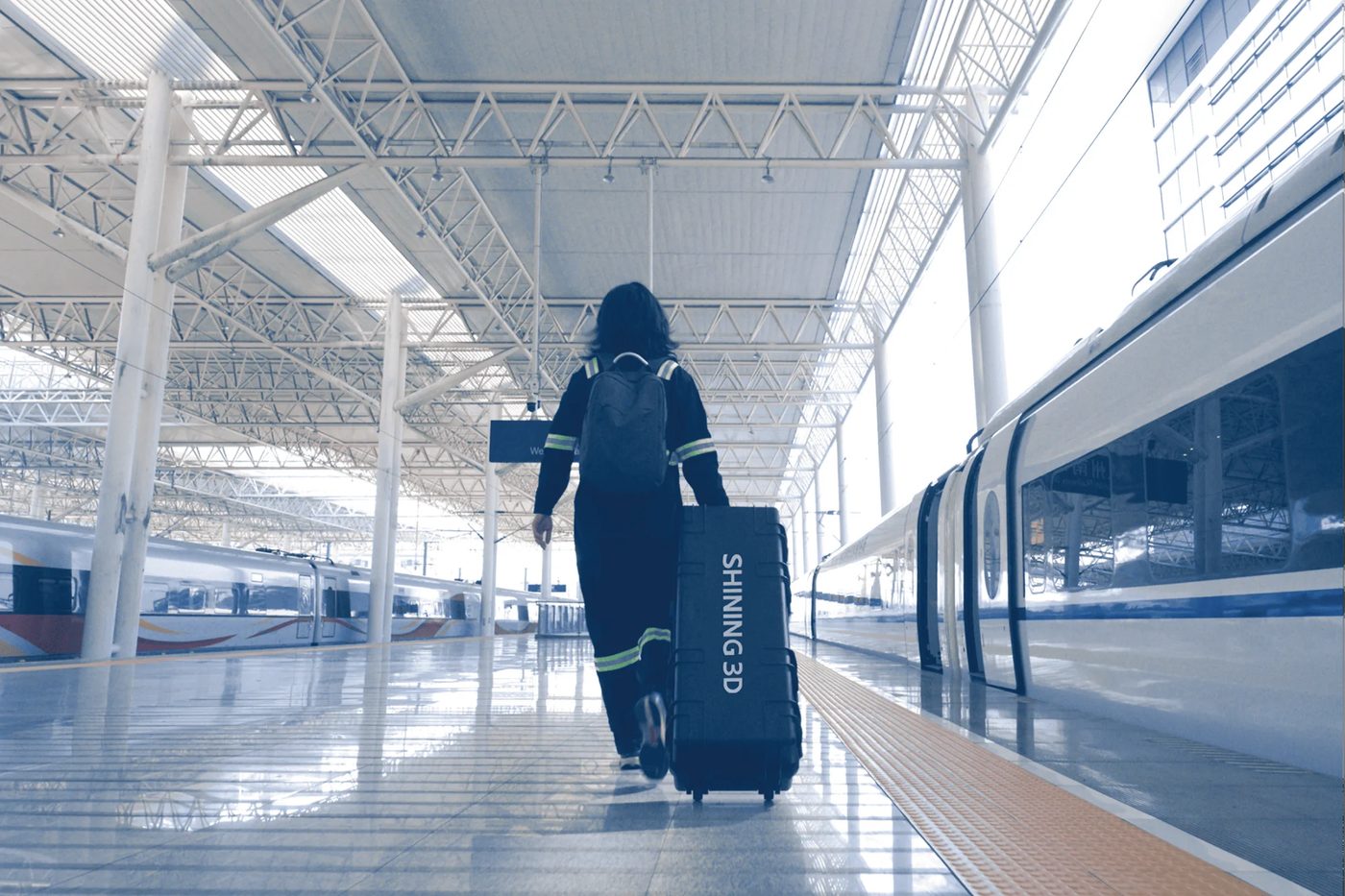 Technician carrying the FreeScan Trak Nova in a backpack and rolling case