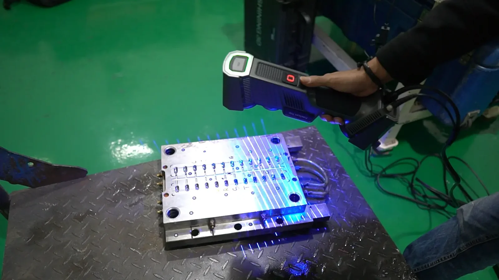 FreeScan Trio capturing a machined injection-mold tooling plate with blue laser lines, producing the certified mesh that feeds part-to-CAD inspection
