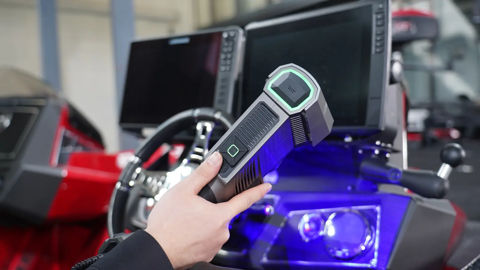 FreeScan Trio held inside a racing boat cockpit — green Trio IR status indicator active, blue IR scatter on dark recessed surfaces, showing marker-free scanning in confined geometry