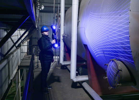 Operator moving freely around a large industrial tank scanning with the cable-free wireless FreeScan UE Nova