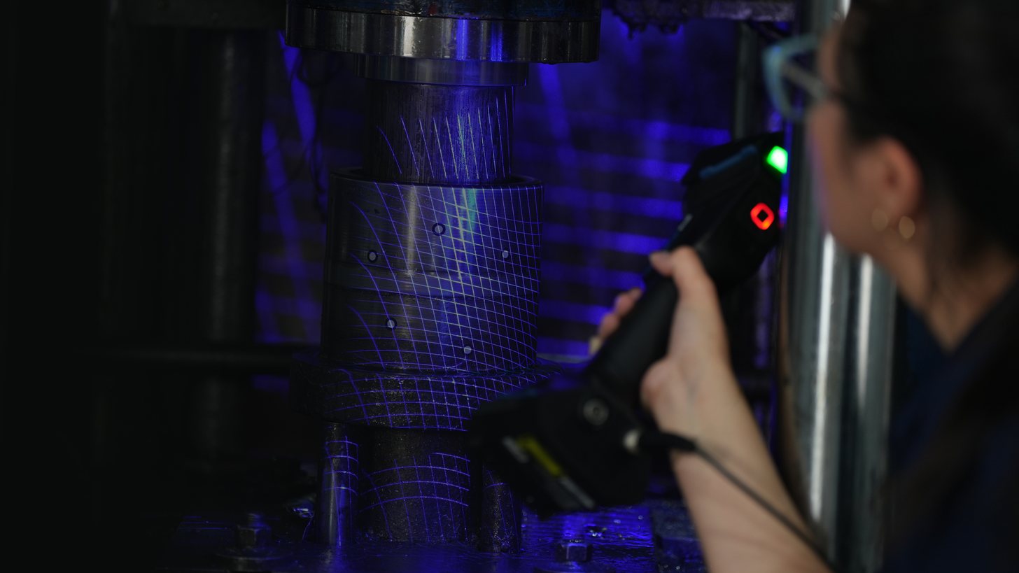Operator capturing a metal punch tool in hand with the wireless FreeScan UE Pro2, blue laser lines active
