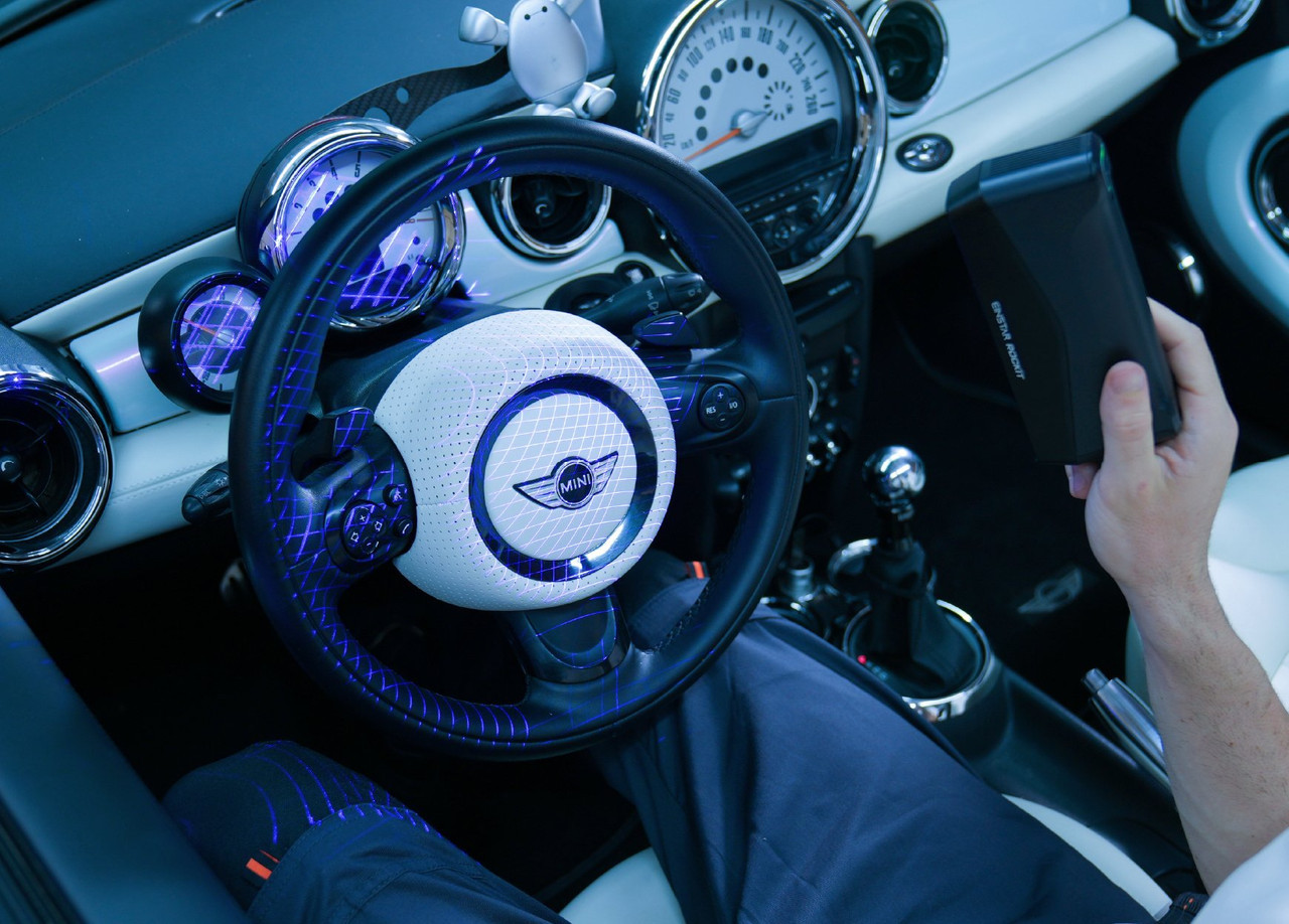 EINSTAR Rockit scanning a car interior wirelessly &mdash; blue laser lines projected across the steering wheel and dashboard, no cables