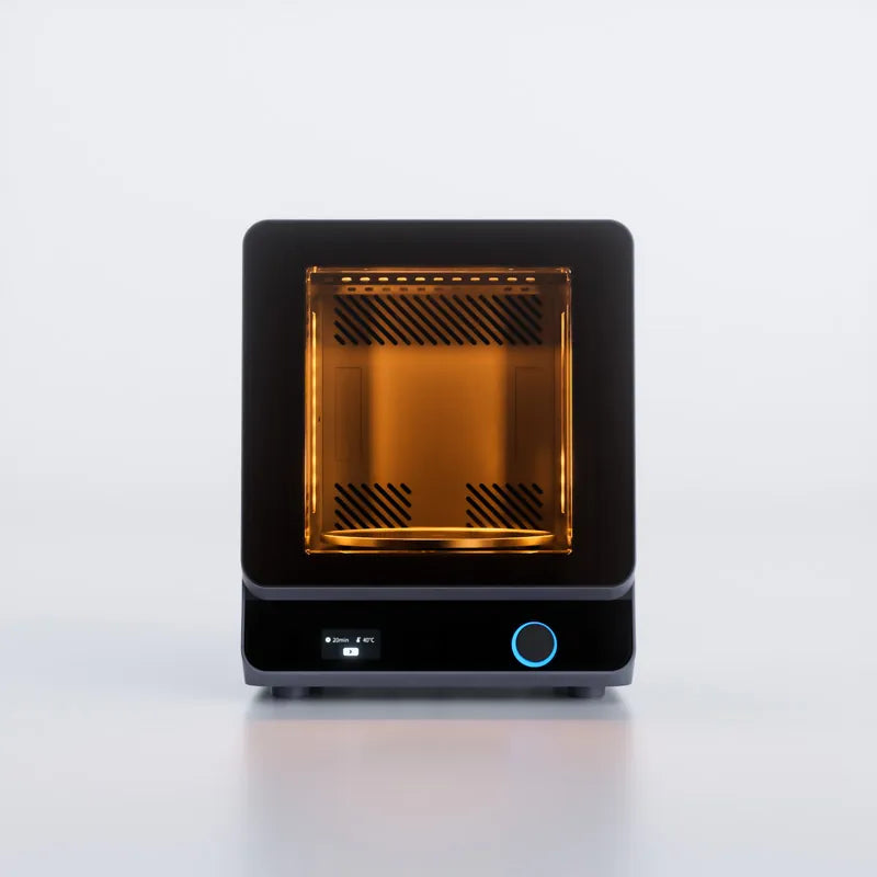HeyGears UltraCraft Cure chamber glowing amber during a heated UV curing cycle, screen showing time and temperature