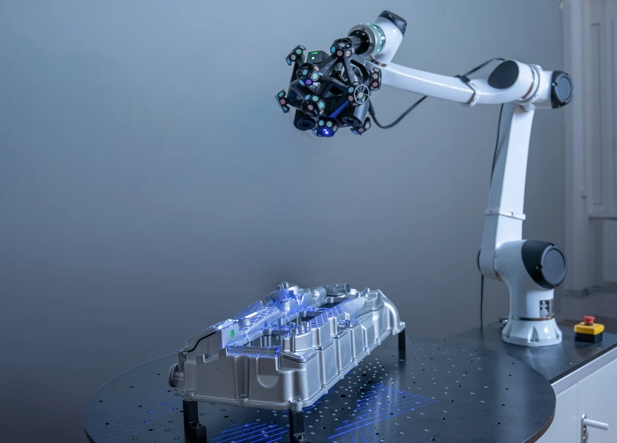 RobotScan cobot arm scanning an aluminium engine block on a turntable with blue structured light