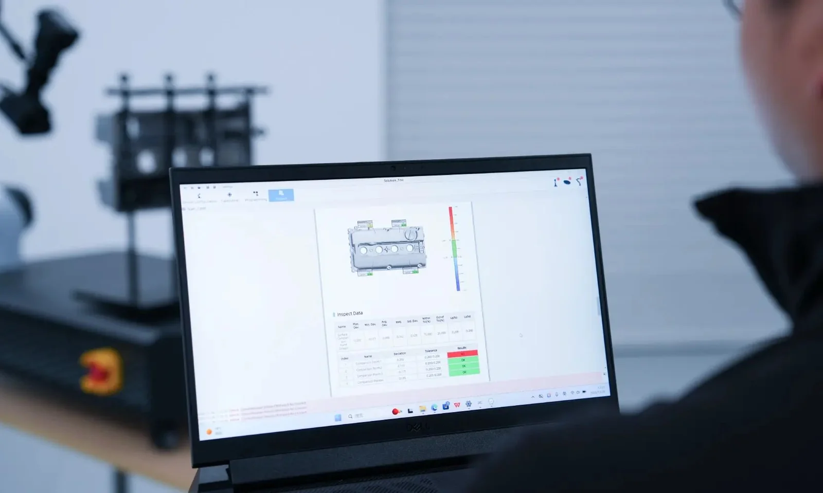 Operator reviewing a SHINING3D Inspect deviation report for a cylinder head cover with pass and fail tolerances