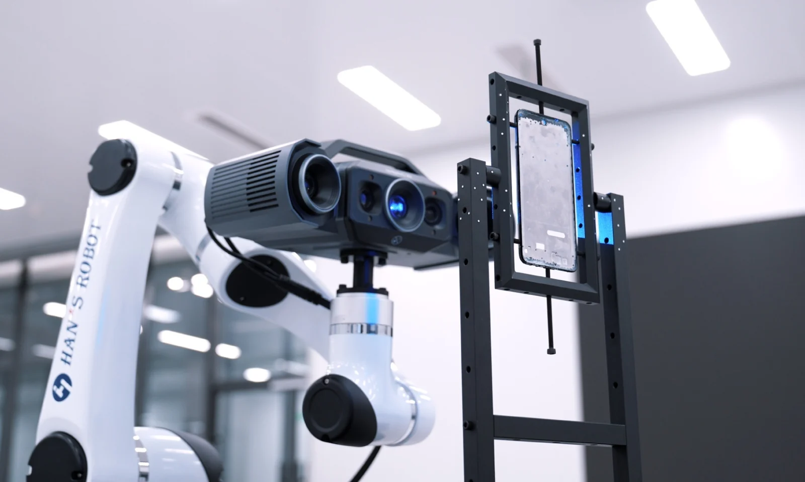 RobotScan OptimScan Q12 fringe-projection scan head mounted on the cobot scanning a phone in a fixture mid-cycle